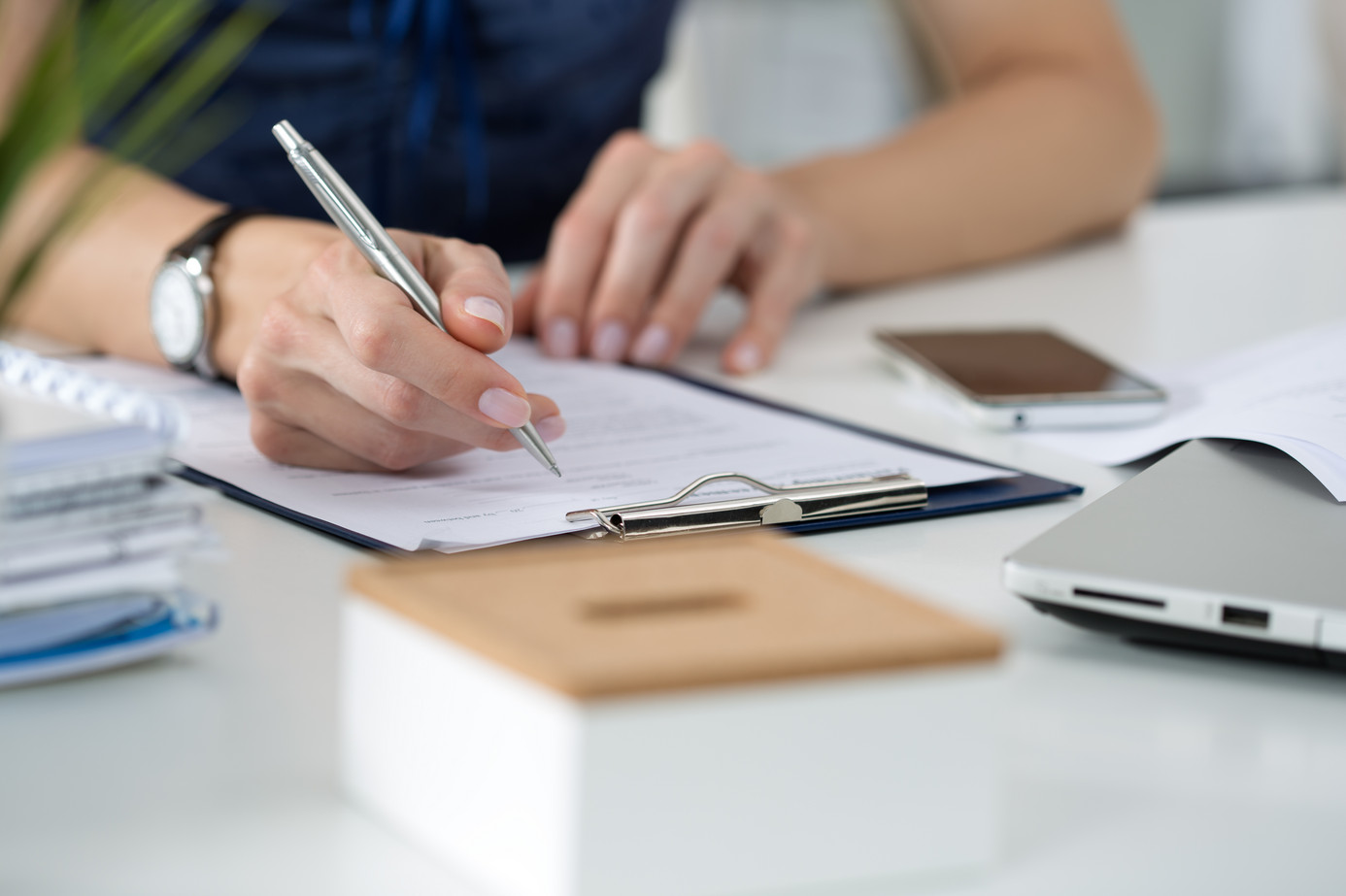 Nahaufnahme Hand mit Stift und Klemmbrett