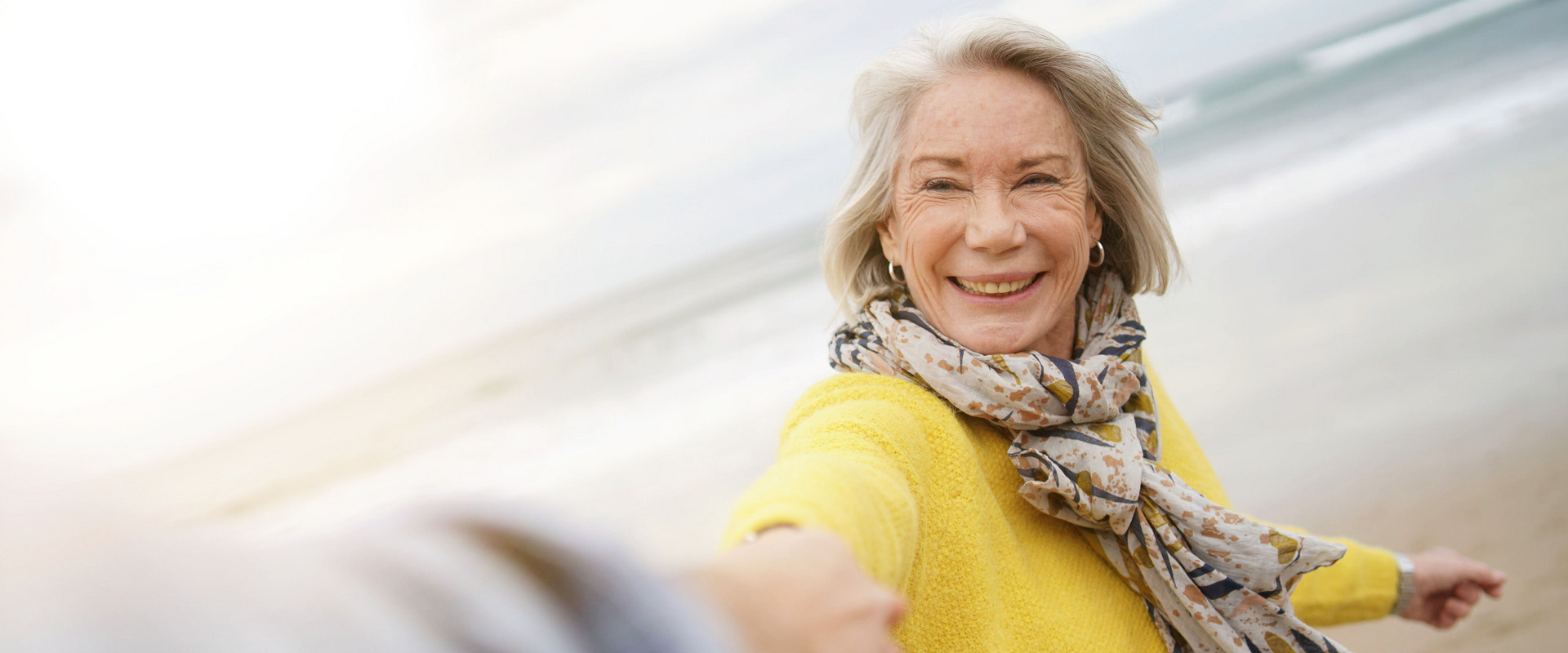 Ältere Dame beim Strandspaziergang